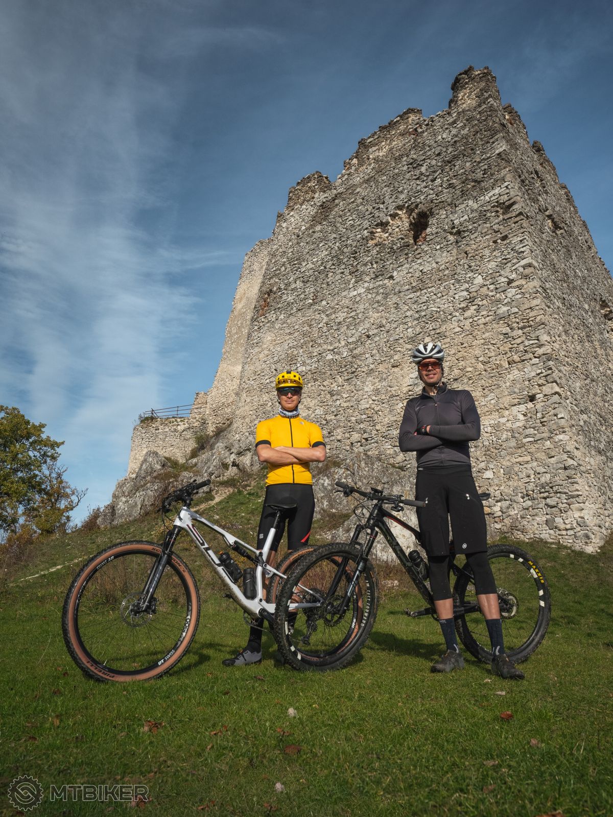 Dvaja cyklisti s bicyklami, v pozadí hrad Tematín