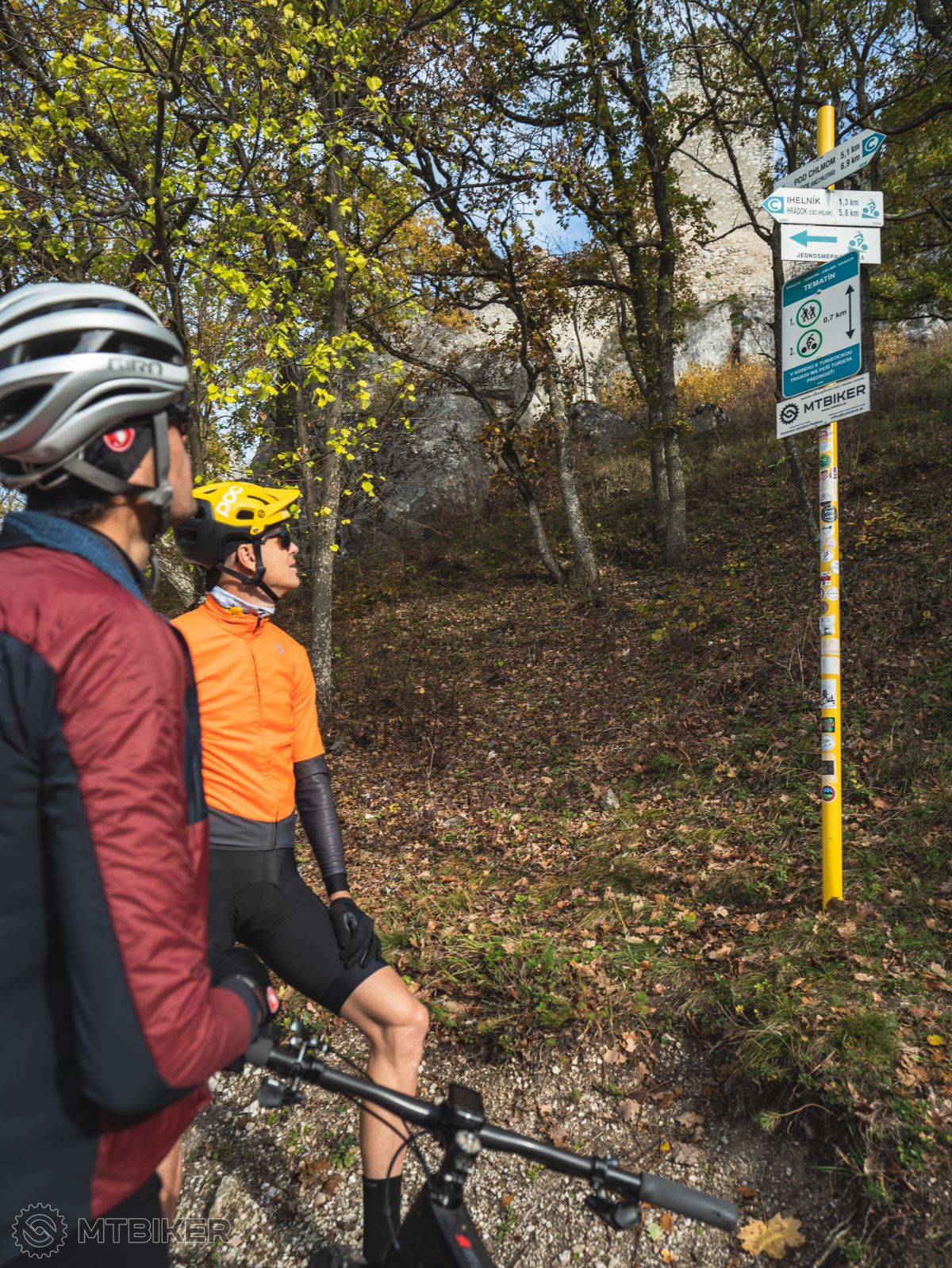Cyklisti pozerajú na turistickú značku pri hrade Tematín